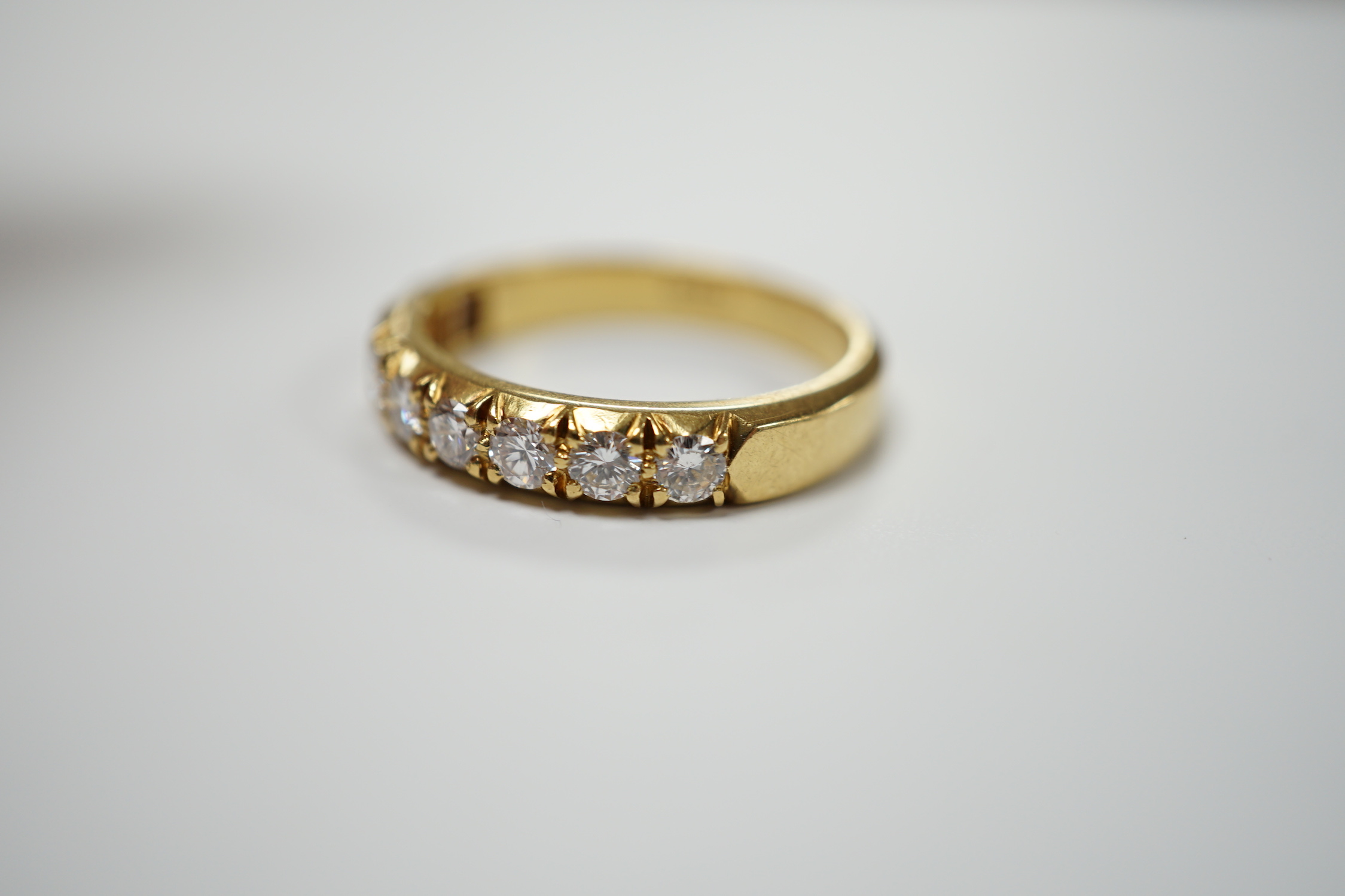 A modern 18ct gold and nine stone diamond set half hoop ring, size R/S, gross weight 6 grams.